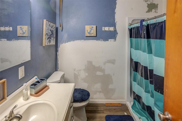 bathroom featuring a shower with shower curtain, hardwood / wood-style floors, vanity, and toilet