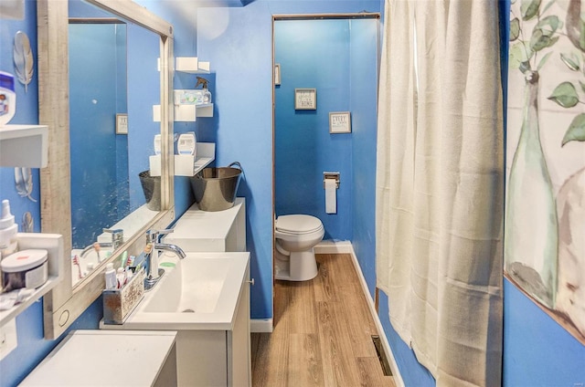 bathroom featuring vanity, wood-type flooring, and toilet