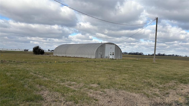 view of outbuilding featuring a yard and a rural view