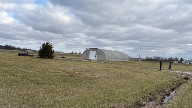 view of yard featuring an outbuilding, a rural view, and a garage