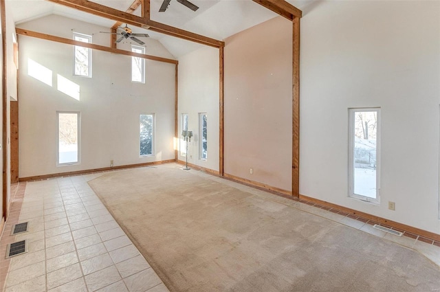 unfurnished living room with ceiling fan, high vaulted ceiling, and light tile patterned floors