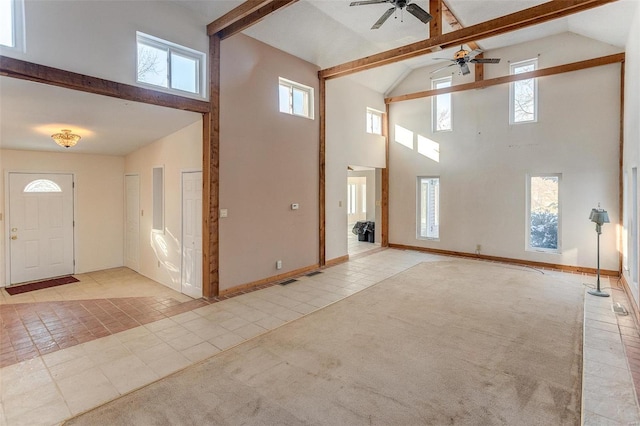 foyer featuring ceiling fan, light tile patterned floors, and high vaulted ceiling