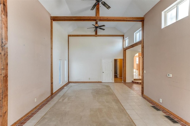 empty room with ceiling fan, beamed ceiling, light tile patterned floors, and high vaulted ceiling