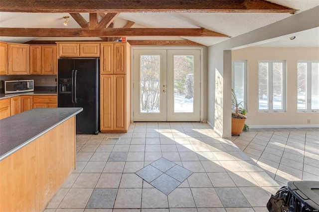 kitchen with lofted ceiling with beams, light tile patterned flooring, black refrigerator with ice dispenser, and french doors