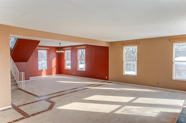 empty room with a textured ceiling and a notable chandelier