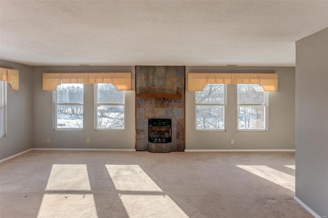 unfurnished living room with heating unit, light carpet, plenty of natural light, and a textured ceiling