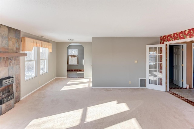 unfurnished living room featuring light carpet and a tile fireplace