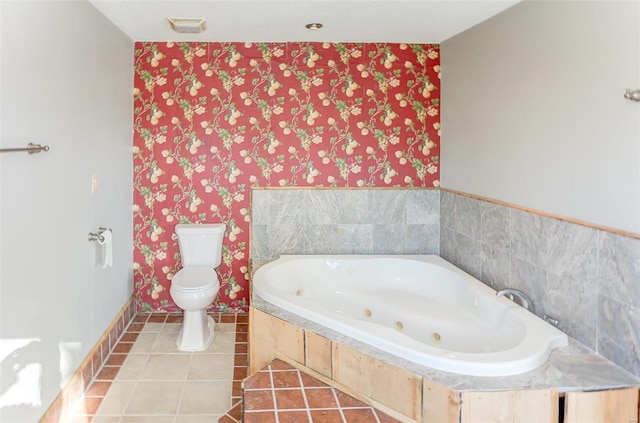 bathroom with tile patterned flooring, a relaxing tiled tub, and toilet