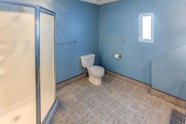 bathroom with a shower with door and toilet