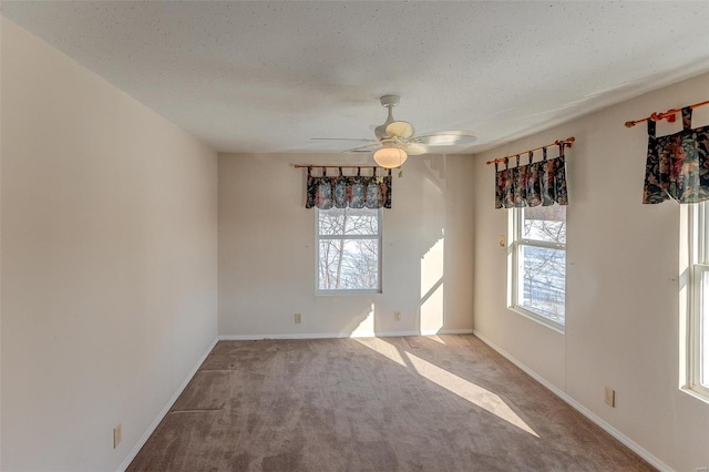 spare room with a textured ceiling, ceiling fan, and light carpet