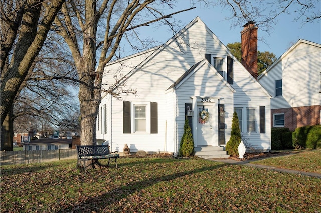 view of front of home featuring a chimney, a front yard, and fence