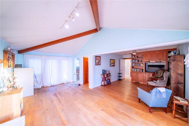 living room featuring a textured ceiling, vaulted ceiling with beams, light hardwood / wood-style floors, and rail lighting