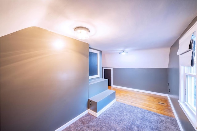 bonus room with light colored carpet and vaulted ceiling