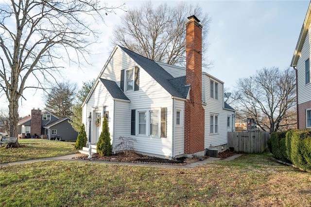 view of side of home with a yard, a chimney, a shingled roof, central AC, and fence