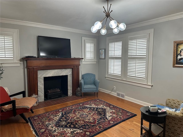 living area with a notable chandelier, visible vents, and crown molding