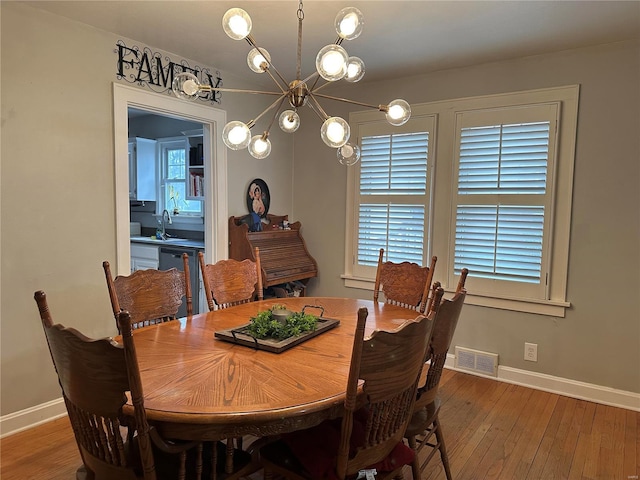 dining room featuring baseboards, visible vents, and hardwood / wood-style floors