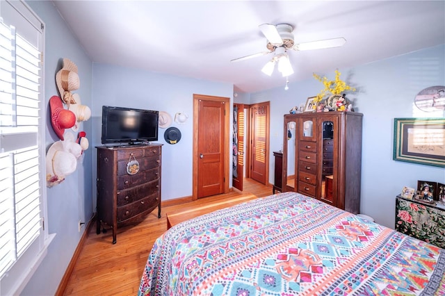 bedroom featuring light wood-style flooring, baseboards, and a ceiling fan