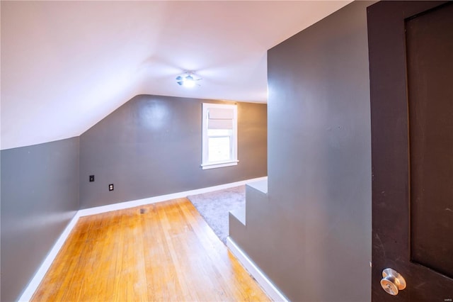 bonus room featuring vaulted ceiling, baseboards, and wood finished floors