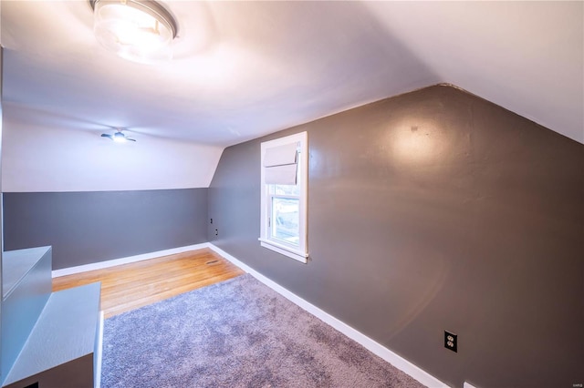 bonus room with lofted ceiling, baseboards, and wood finished floors