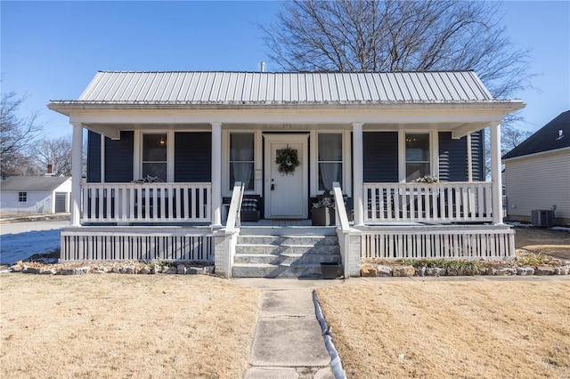 bungalow-style house with a porch and central AC unit