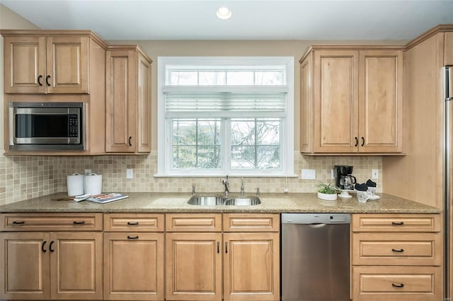 kitchen with stainless steel appliances, light countertops, a sink, and tasteful backsplash