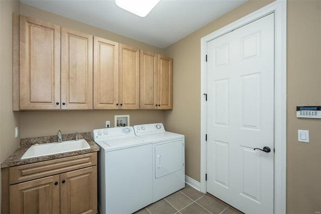 washroom with cabinet space, a sink, independent washer and dryer, baseboards, and tile patterned floors