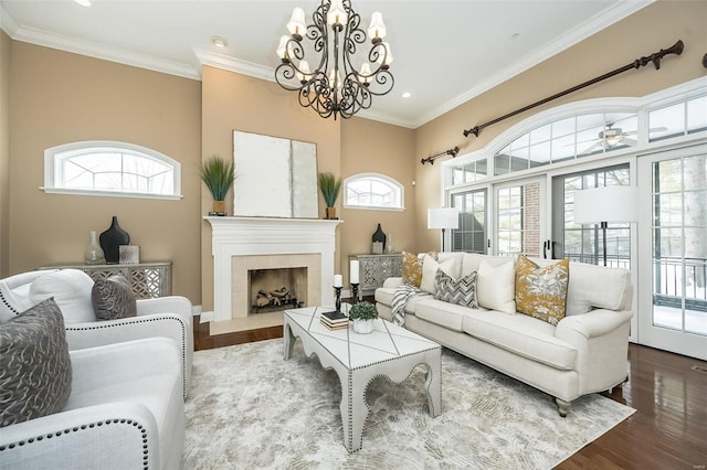 living area featuring a healthy amount of sunlight, crown molding, and wood finished floors