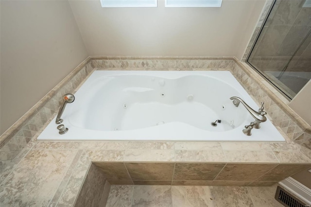 bathroom featuring a jetted tub and visible vents