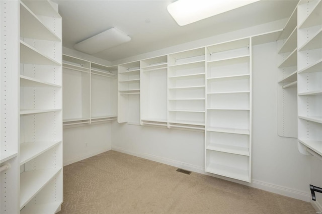 spacious closet featuring light carpet and visible vents