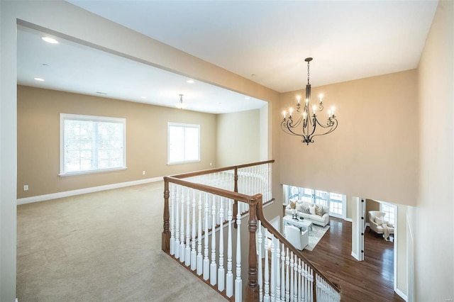 hall featuring carpet floors, recessed lighting, an upstairs landing, a chandelier, and baseboards