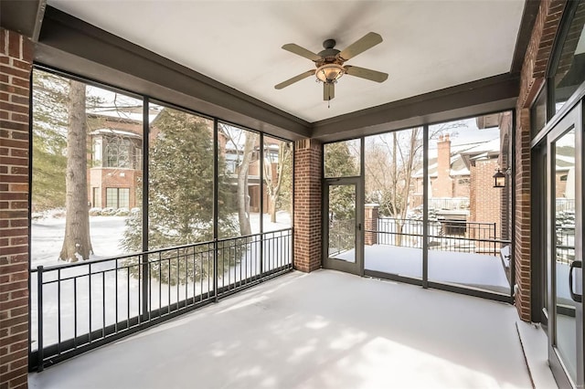 unfurnished sunroom with ceiling fan