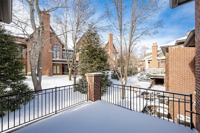 view of snow covered back of property