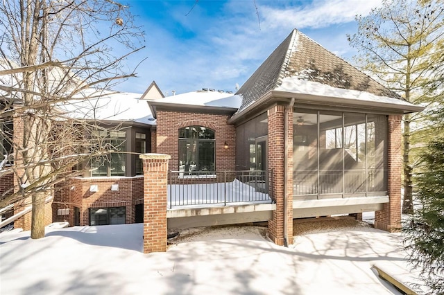 exterior space featuring a sunroom and brick siding