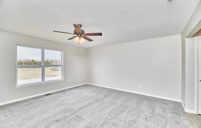 empty room with ceiling fan and light colored carpet