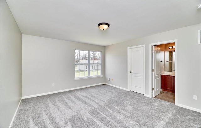 unfurnished bedroom with light colored carpet and ensuite bath