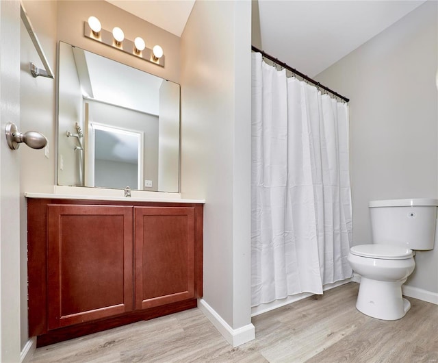 bathroom featuring toilet, vanity, and hardwood / wood-style flooring