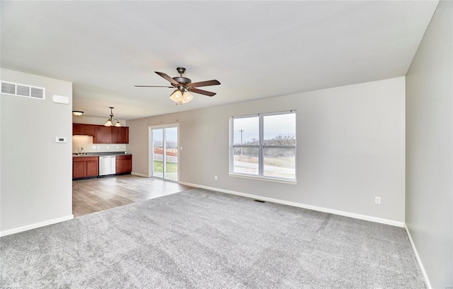 unfurnished living room featuring ceiling fan and light colored carpet