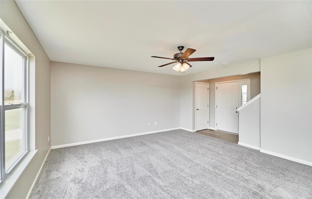 carpeted empty room featuring ceiling fan and a healthy amount of sunlight