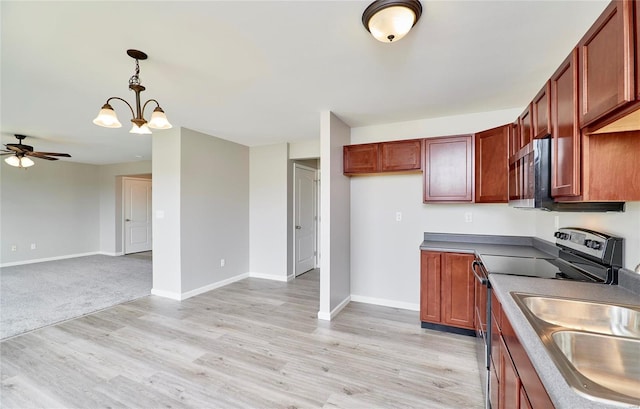 kitchen featuring pendant lighting, stainless steel appliances, ceiling fan with notable chandelier, and light hardwood / wood-style flooring