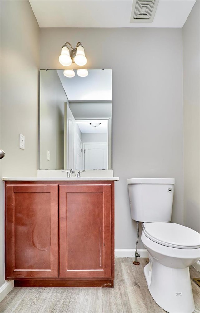 bathroom with vanity, wood-type flooring, and toilet