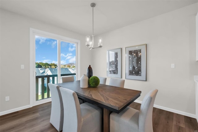 dining space with dark wood-type flooring, a water view, and a chandelier