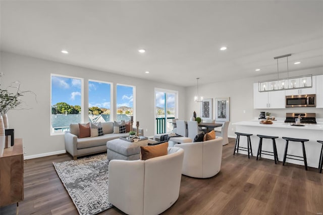 living room with dark hardwood / wood-style flooring and a water view