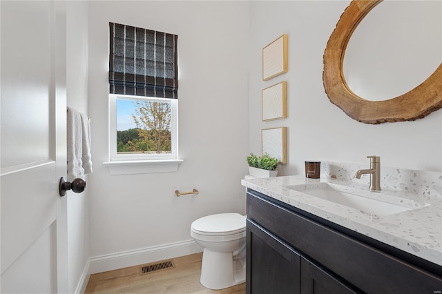 bathroom with hardwood / wood-style flooring, vanity, and toilet