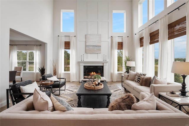 living room with a high ceiling, a healthy amount of sunlight, and hardwood / wood-style floors