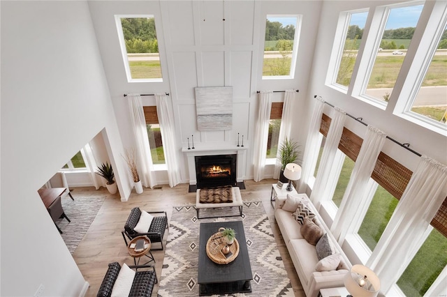 living room with light hardwood / wood-style floors and a high ceiling