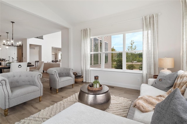 sitting room featuring hardwood / wood-style floors, a notable chandelier, and lofted ceiling