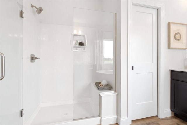 bathroom featuring hardwood / wood-style floors, vanity, and walk in shower