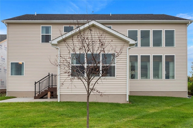 rear view of house featuring a yard