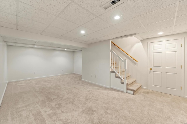 basement with a drop ceiling and carpet