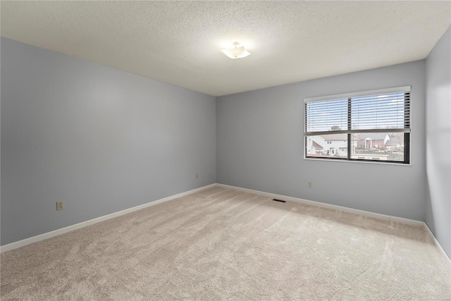 carpeted empty room featuring a textured ceiling